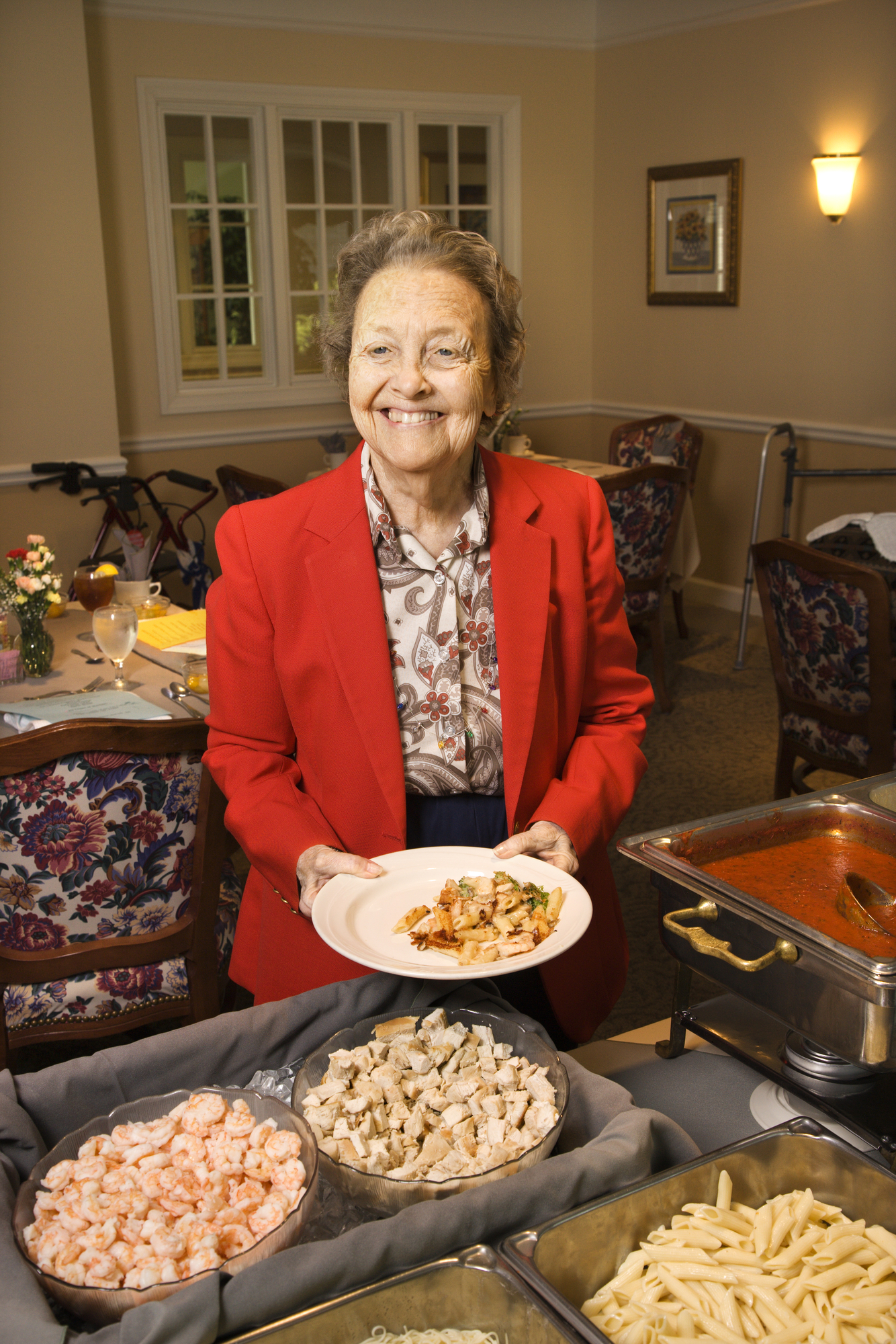 Elderly Caucasian woman at buffet in the dining room of a retirement community center.